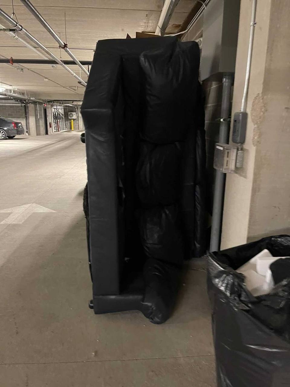 Large padded furniture sections staged in a parking garage