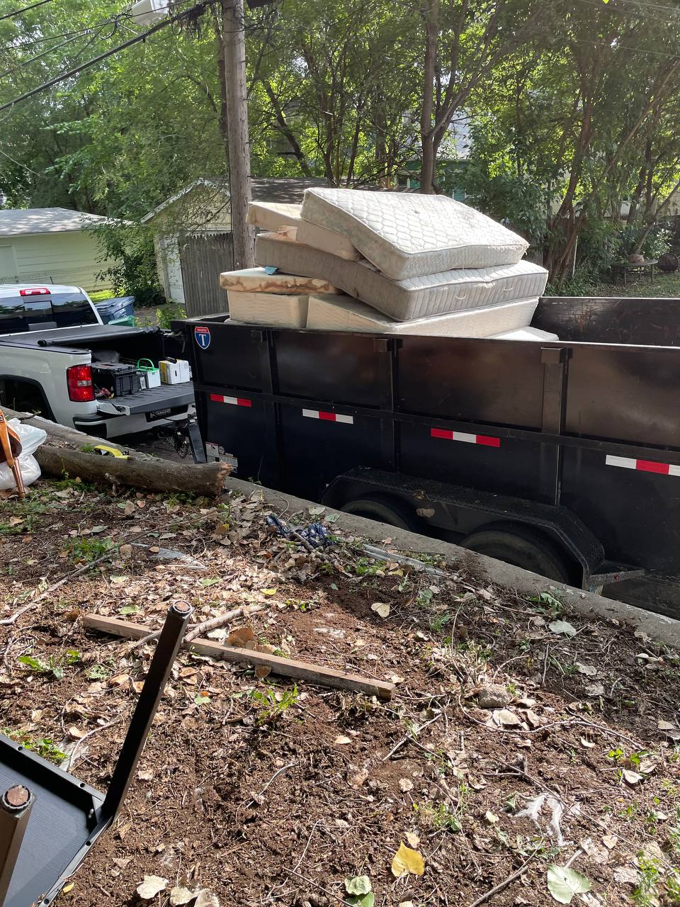 Mattresses stacked in a dump trailer for removal